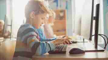 Photo a boy works on a computer in a classroom.