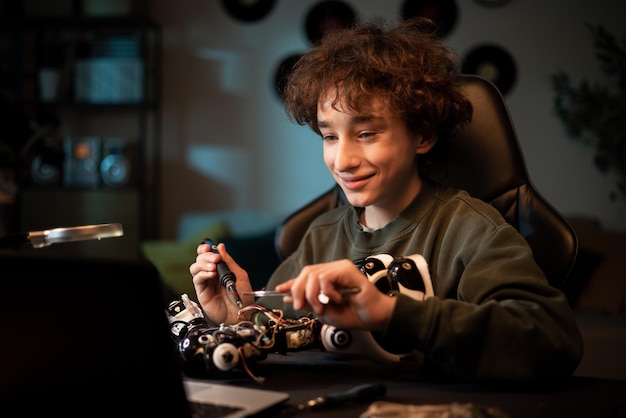 A boy works to create a fully functional robot from scratch a bright teenager soldering