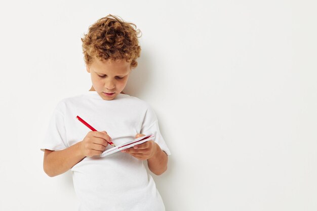 Boy writing in diary against white background