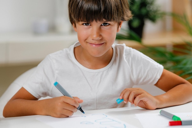 Photo boy writing letters on preschool screening test