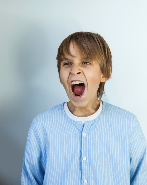 Boy yawning against white background