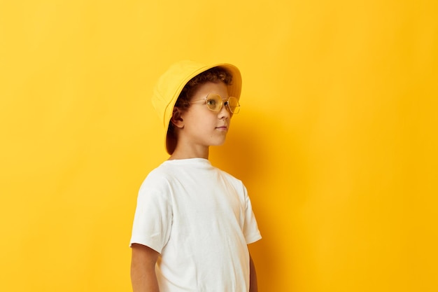 Boy in yellow hat with glasses childrens fashion yellow background