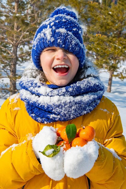 The boy in a yellow jacket with tangerines high quality photo