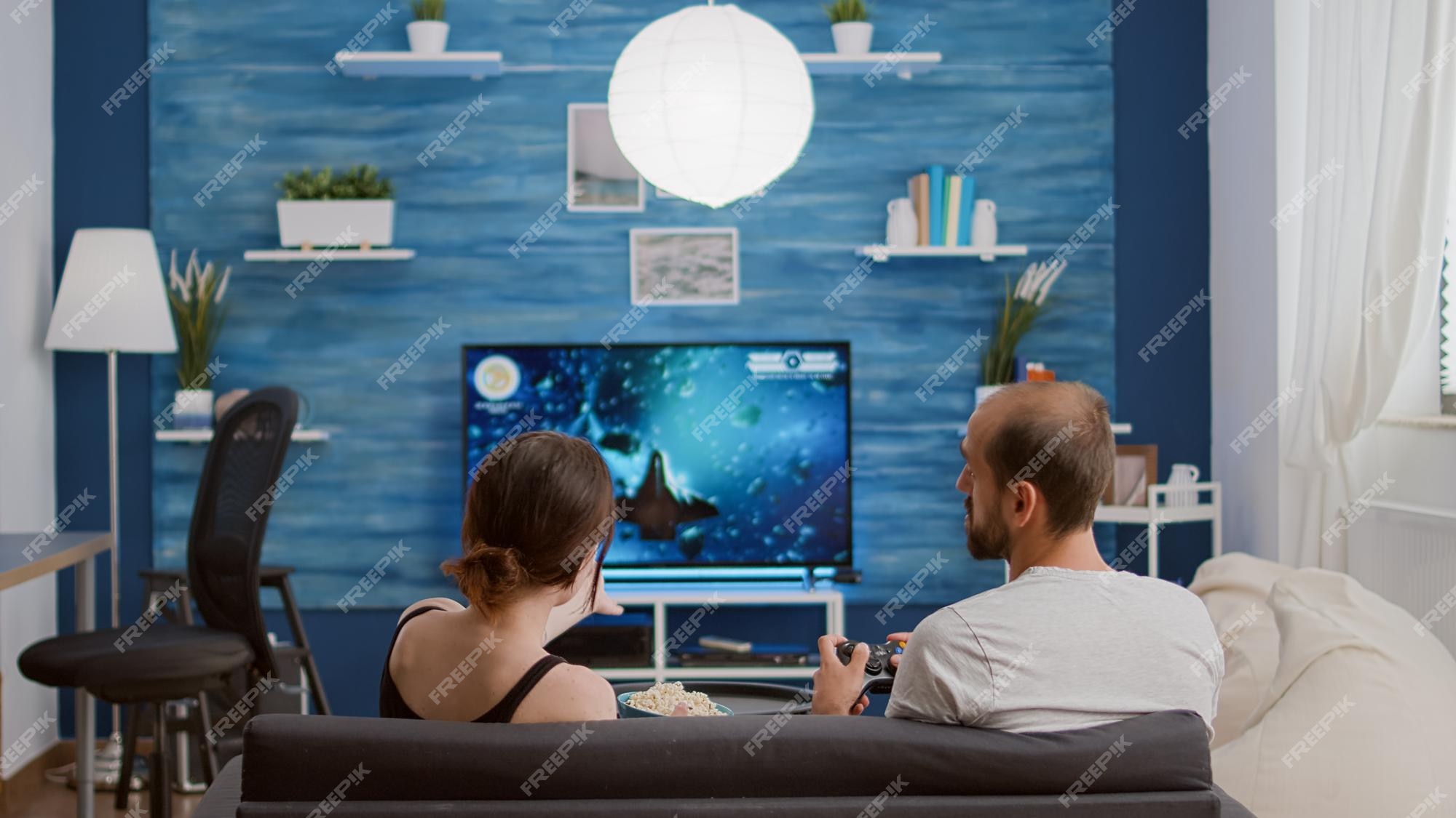 Man disappointed while playing video game with girlfriend at home stock  photo