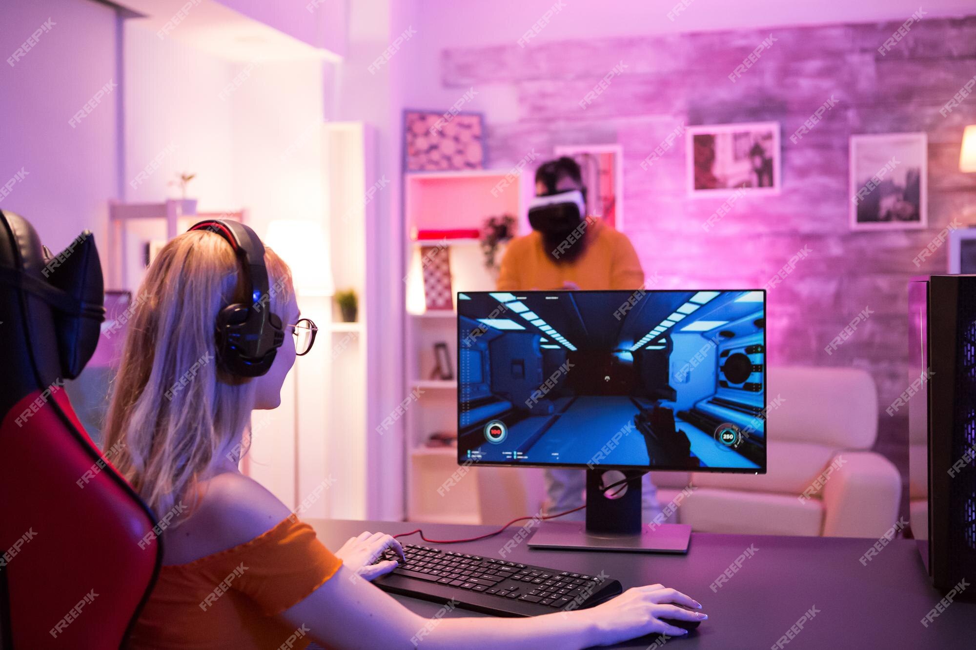 Premium Photo  Boyfriend cheering her beautiul girlfriend while she's playing  online games using wireless controller. room with neon light.