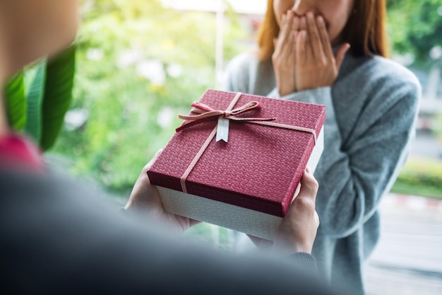Парень удивляет и дарит своей девушке подарочную коробку