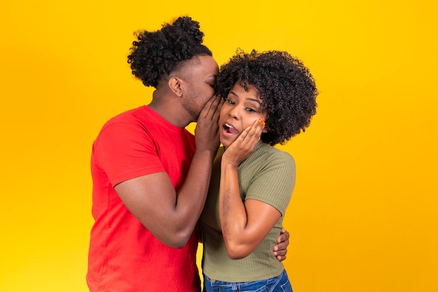 Boyfriend telling a secret in his girlfriend's ear who is shocked by the gossip