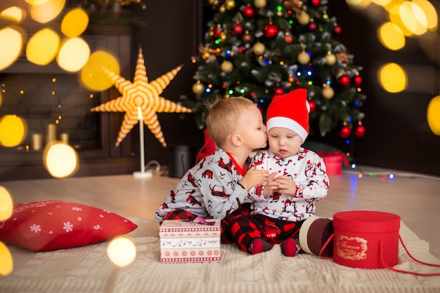 Boys, brothers, kids in Christmas costumes, pajamas with Christmas decorations