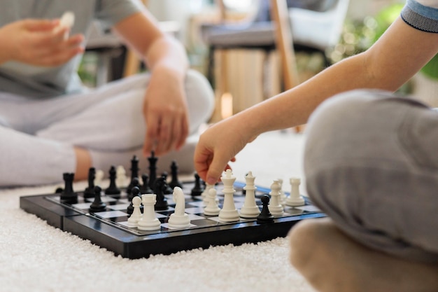 boys brothers play chess on the living room floor on a white carpet