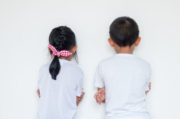 Boys and girls standing in front of the wall in the corner of the room