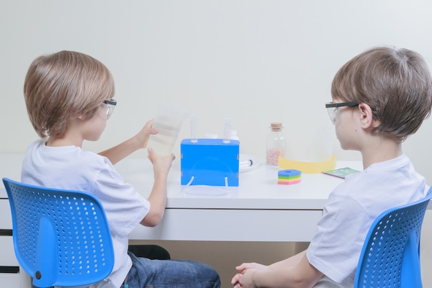 Мальчики делают научные эксперименты концепция образования