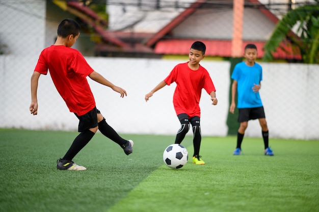 サッカー練習場でサッカーをしている男の子