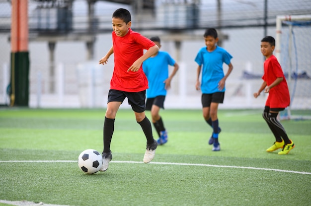 サッカー練習場でサッカーをしている男の子