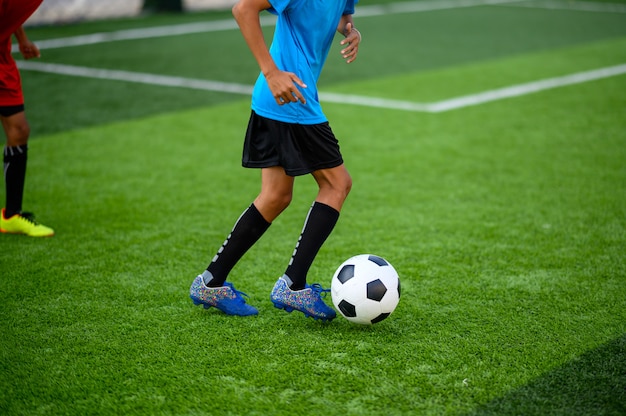 サッカー練習場でサッカーをしている男の子