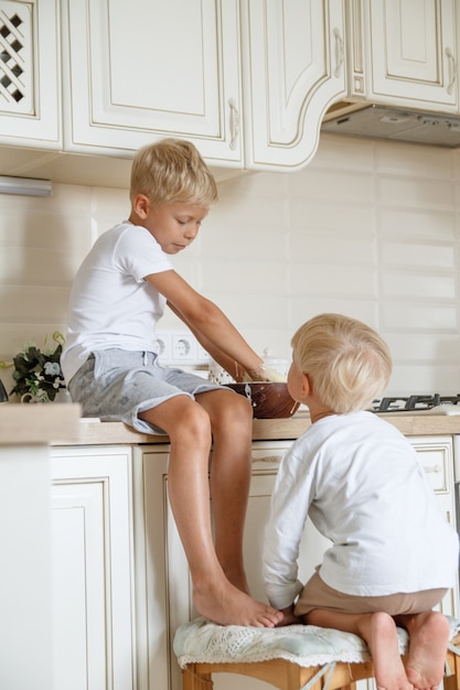 Ragazzi che preparano la torta fatta in casa in cucina. due fratelli cooki