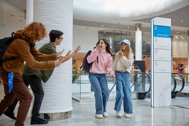 Photo boys scaring girls for joke children spending time at shopping mall