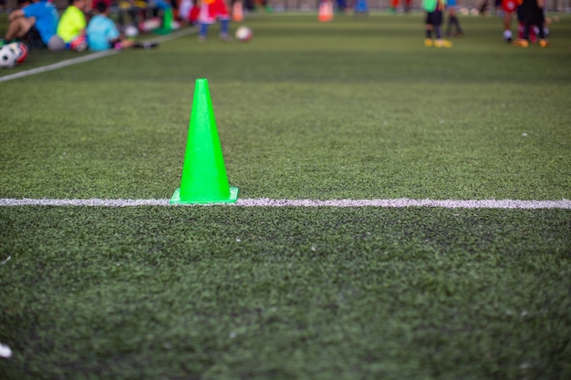 Тактика футбольного мяча для мальчиков на травяном поле с конусом
