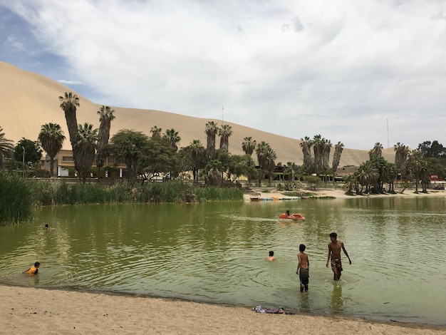 Photo boys swimming in lake at huacachina