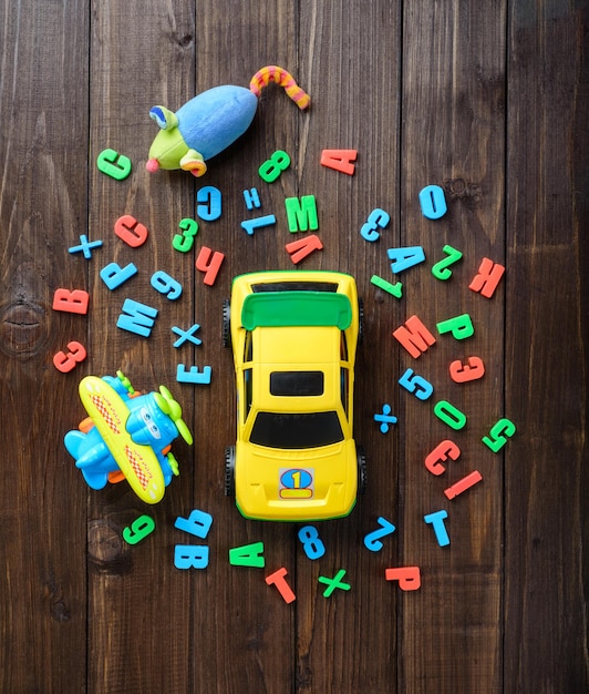 Photo boys toys and colord letters on wooden table top view