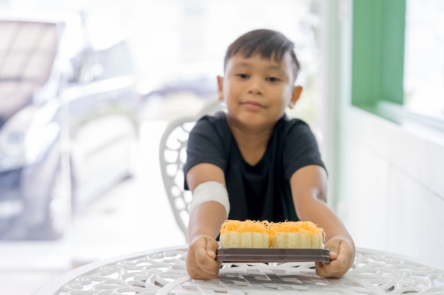 The boys at the wounded hands Hold a Gold Egg Yolk Thread Cakes