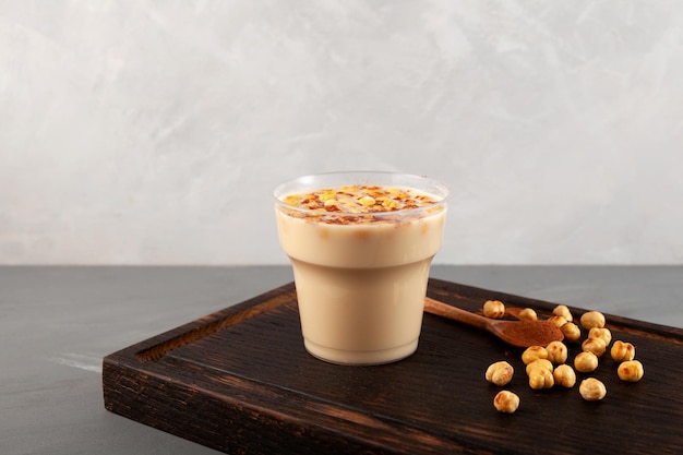 Boza or Bosa in disposable plastic take away cup Turkish fermented drink with roasted chickpea