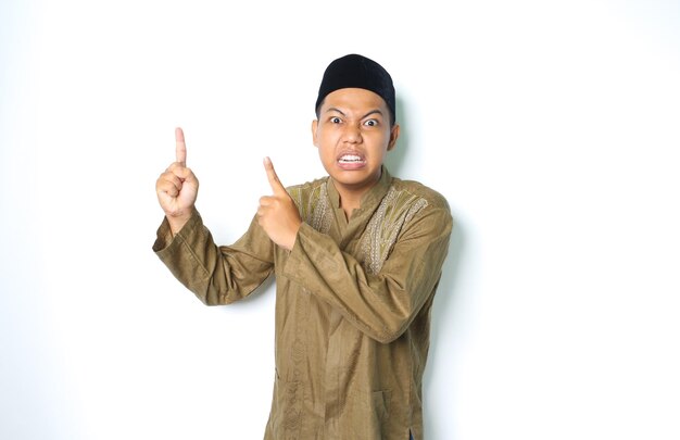 boze Aziatische moslim man draagt Arabisch kostuum omhoog en kijk naar camera geïsoleerd op een witte achtergrond