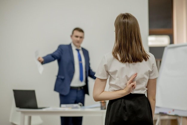 Boze baas die tegen zijn jonge werknemer schreeuwt, ze is gestrest en voelt zich gefrustreerd: vijandige baas en mobbing-concept.