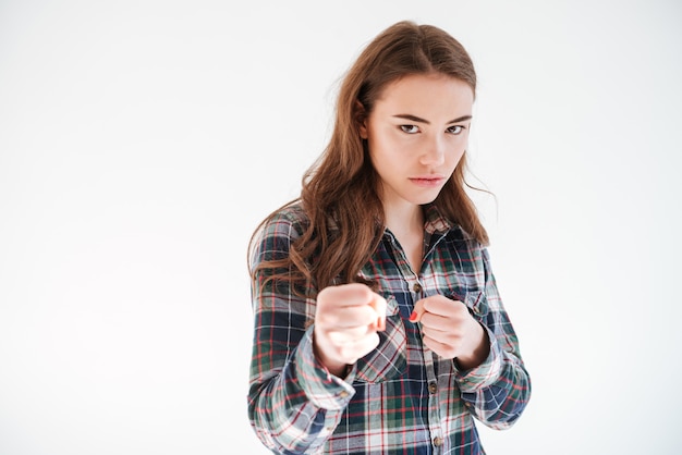 Boze geconcentreerde jonge vrouw met vuisten klaar om te vechten