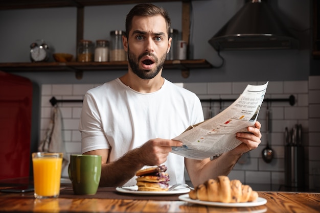 Boze geschokte man ontbijten, krant lezen
