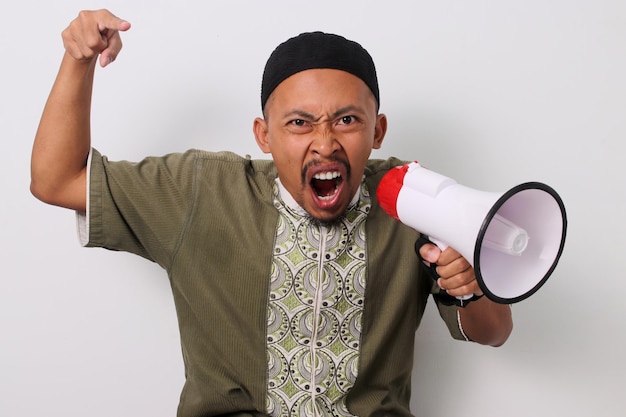 Boze Indonesische man schreeuwt aankondiging houdt megafoon vast