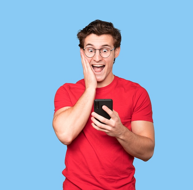 Boze jonge man met behulp van een mobiele telefoon