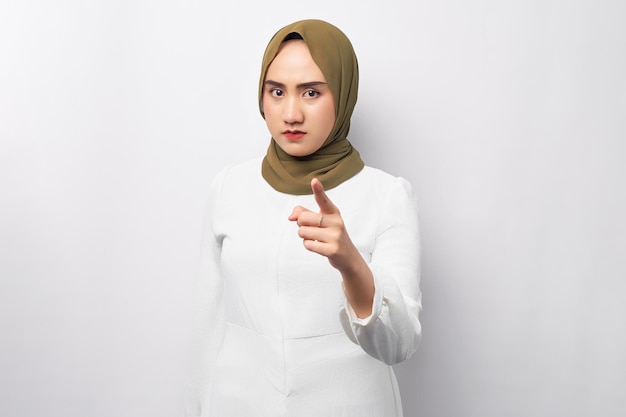 Boze jonge mooie Aziatische moslimvrouw 20s dragen hijab wijst haar vinger naar de camera geïsoleerd op witte achtergrond Mensen religieuze levensstijl concept