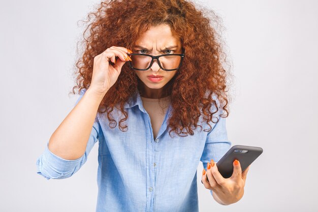 Foto boze krullende jonge vrouw praten aan de telefoon afbeelding van schreeuwende agressieve jonge vrouw