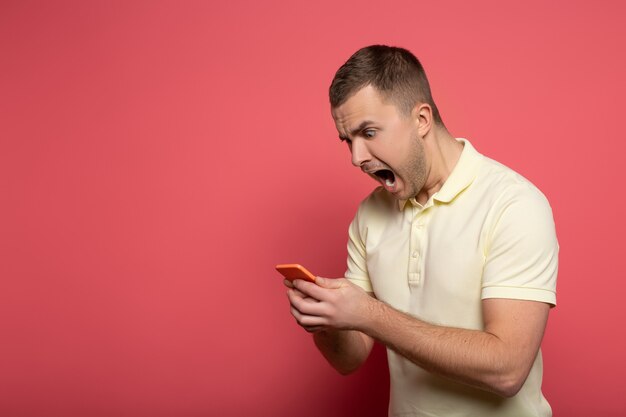 Boze man met smartphone op roze