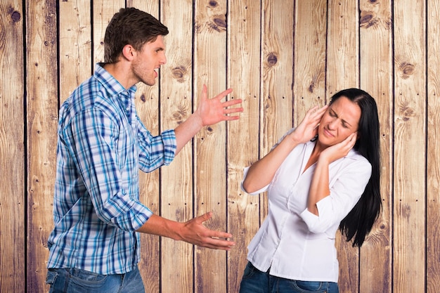 Boze man ruzie met vrouw tegen houten muur