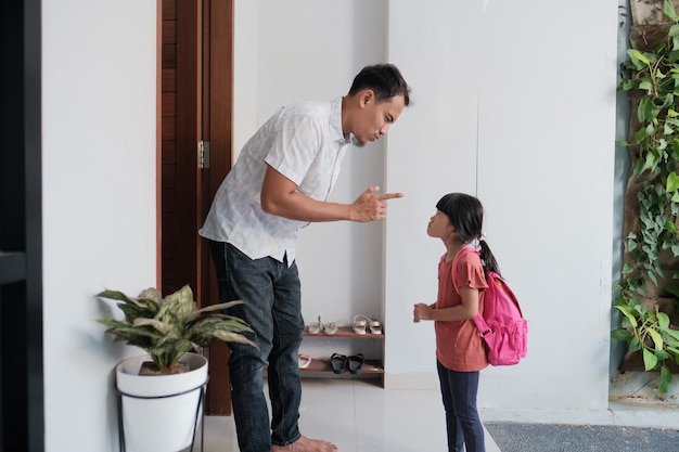 Boze vader confronteert zijn kind na school. Aziatische primaire student probleem. gewelddadige ouder met dochter