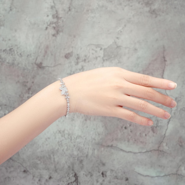 bracelet inlaid with a diamond on hand isolated on gray background