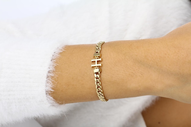 A bracelet with a gold chain and the word love on it.