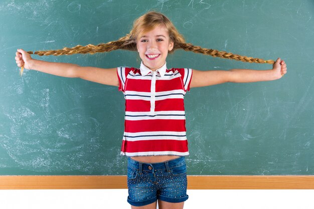 Braided student blond girl playing with braids