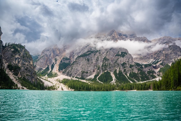 Braies meer omringd door dennenbossen en de rotsachtige bergketens van de Dolomieten op bewolkte dagen in Italië