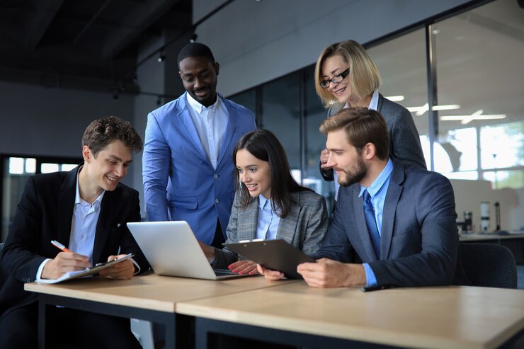 Photo brainstorm. group of business people looking at the laptop together. one business woman looking at camera.