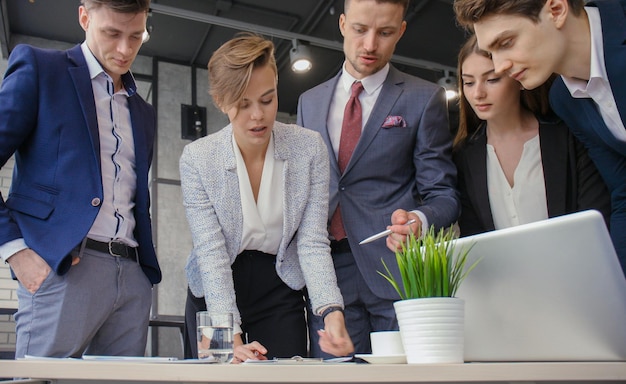 Brainstorm Group of business people looking at the laptop together