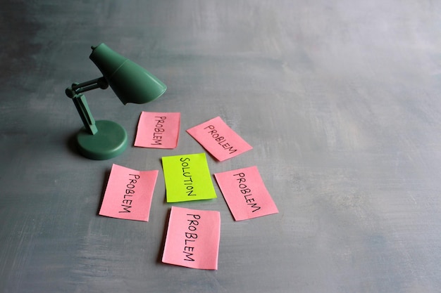 Brainstorming concept desk lamp red paper with text problem and\
green paper with text solution