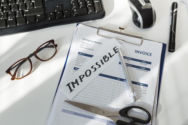 brainstorming. impossible word on workplace of sales manager with document invoice.