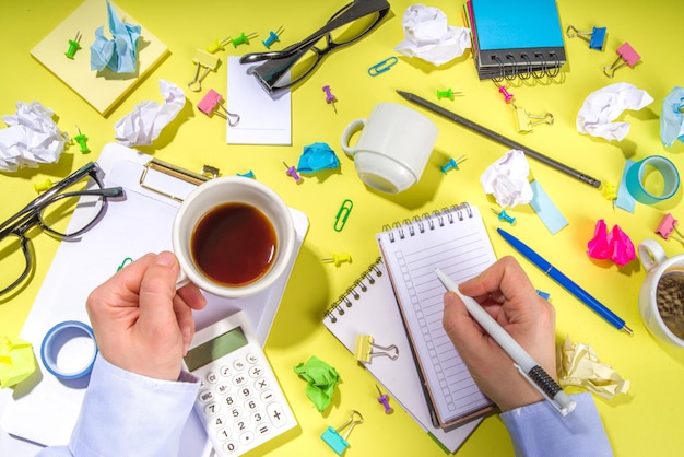 Brainstorming office table background Office work table with notepads pens pencils crumpled colorful paper office supplies Creative business team brainstorming concept flatlay yellow background