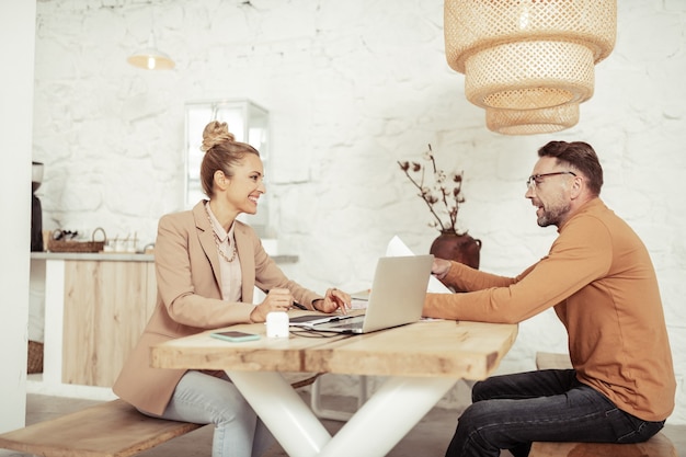 Photo brainstorming. two smiling colleagues sitting together at the table and talking looking for new design ideas.