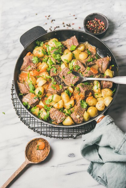 Braised beef meat with potato and carrot with fresh parsley