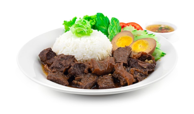 Braised beef stew with Rice and Egg recipe served chili fish Sauce decoration carving vegetables Thai Style sideview