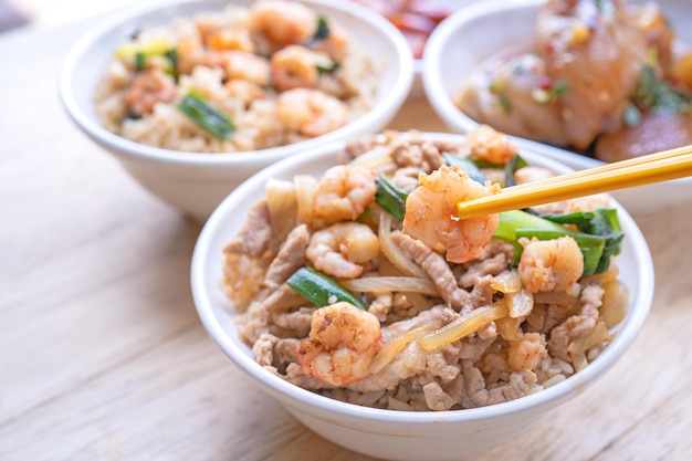 米にエビを煮込んだ台湾の有名な伝統的な屋台の食べ物海老の煮物と豚肉の炊き込みご飯にスライスした豚肉旅行コンセプトのコピースペースをクローズアップ
