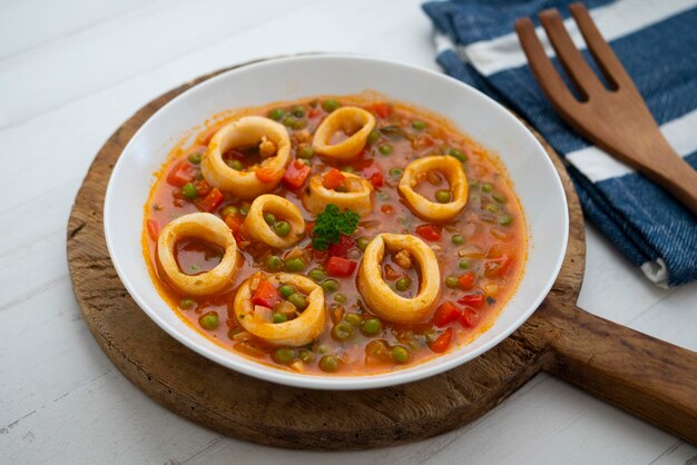 Braised squid rings with tomato and vegetables. Traditional Spanish tapa recipe.